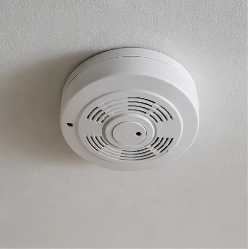 Hardwired smoke detector mounted on interior ceiling