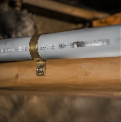 Insulated water supply pipe strapped to floor joist in crawlspace