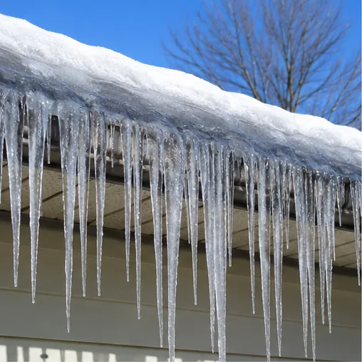 Ice dam with hanging icicles along snow-covered gutter found during a South Haven home inspection