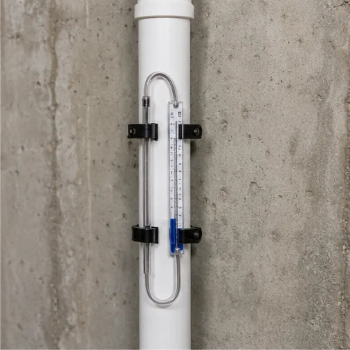 Radon test manometer on a radon mitigation pipe